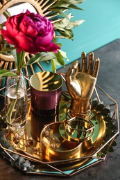 Photo of Composition with stylish accessories and interior elements on table near turquoise wall