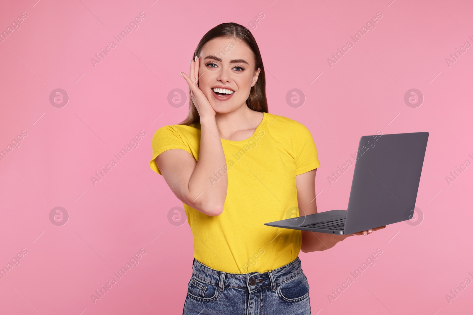 Photo of Happy woman with laptop on pink background