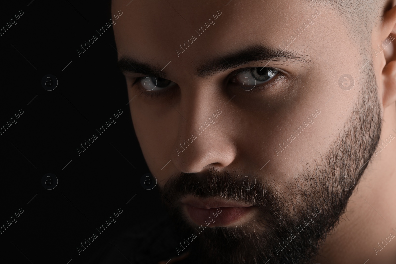 Photo of Evil eye. Man with scary eyes on black background