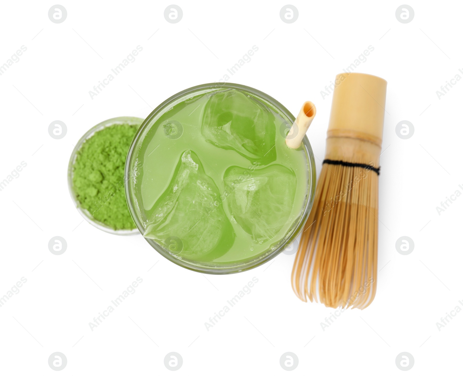 Photo of Glass of delicious iced green matcha tea, powder and bamboo whisk isolated on white, top view