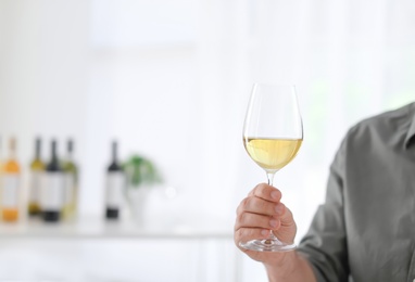 Young man with glass of wine indoors