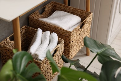 Photo of Storage baskets with folded white towels indoors