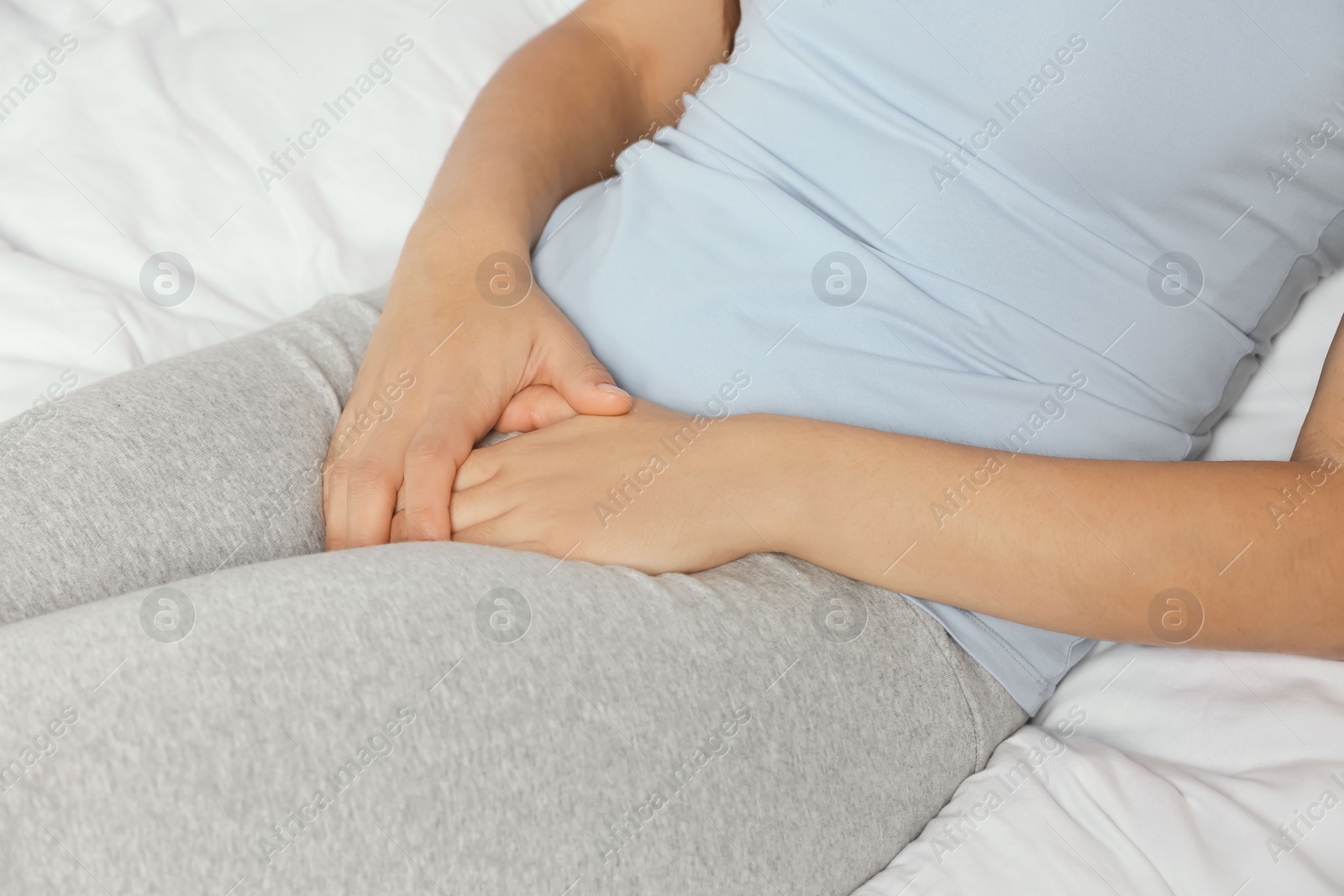 Photo of Woman suffering from genital herpes on bed, closeup