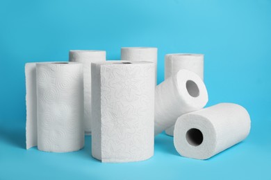 Photo of Many rolls of paper towels on light blue background