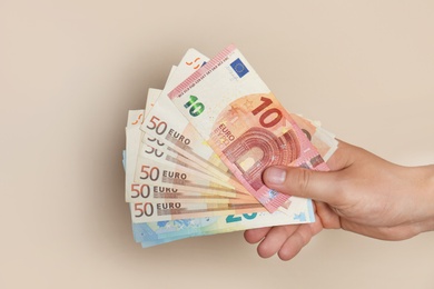 Photo of Man with Euro banknotes on brown background, closeup