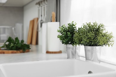 Different potted artificial plants on countertop in kitchen, space for text. Home decor