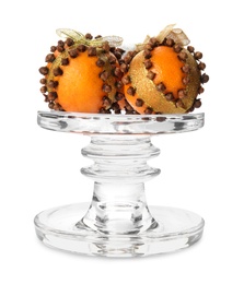 Glass stand with tangerine pomander balls isolated on white
