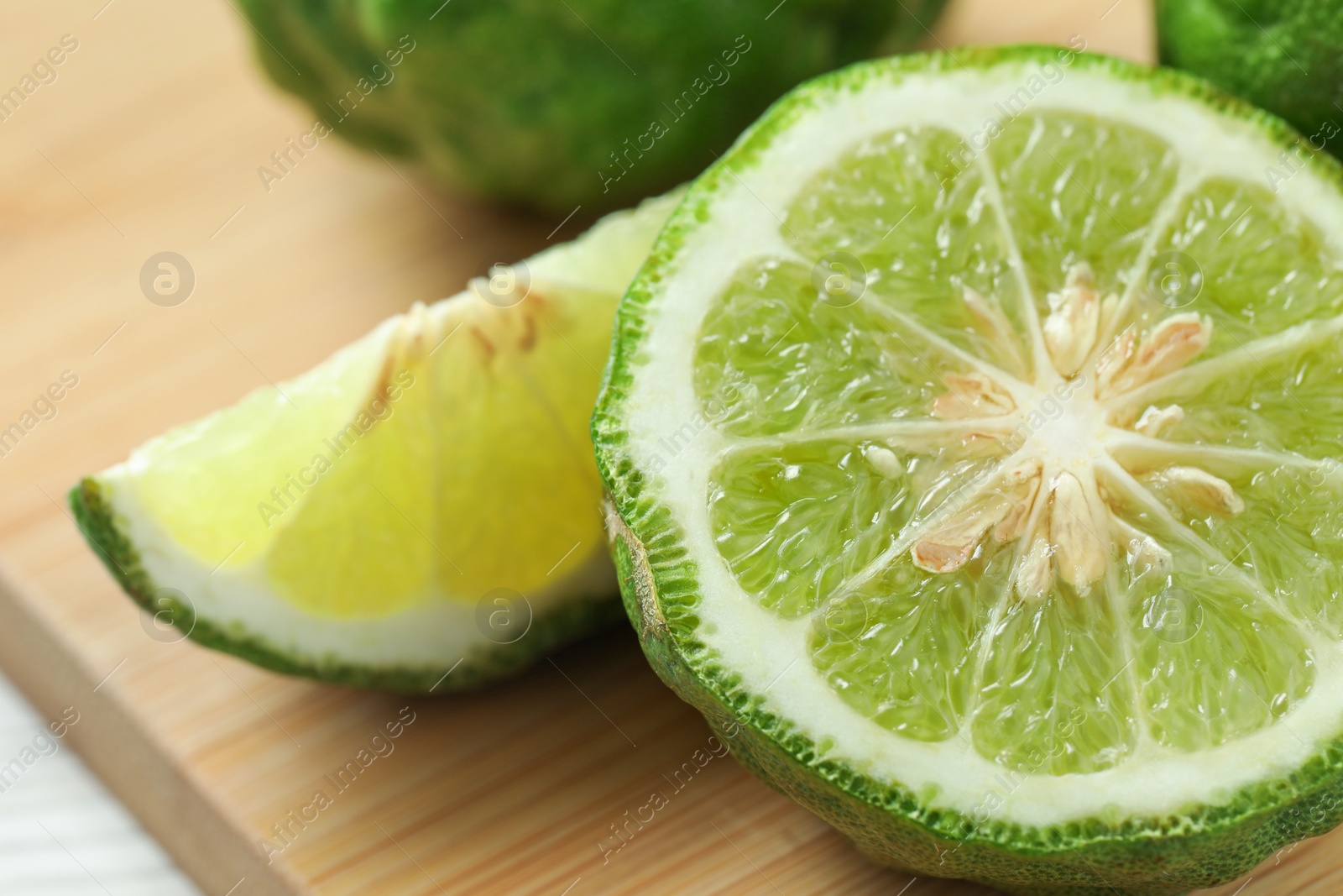 Photo of Cut ripe bergamot fruit on wooden board, closeup