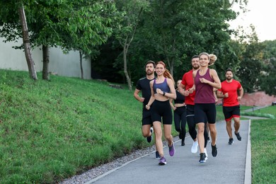Photo of Group of people running outdoors. Space for text