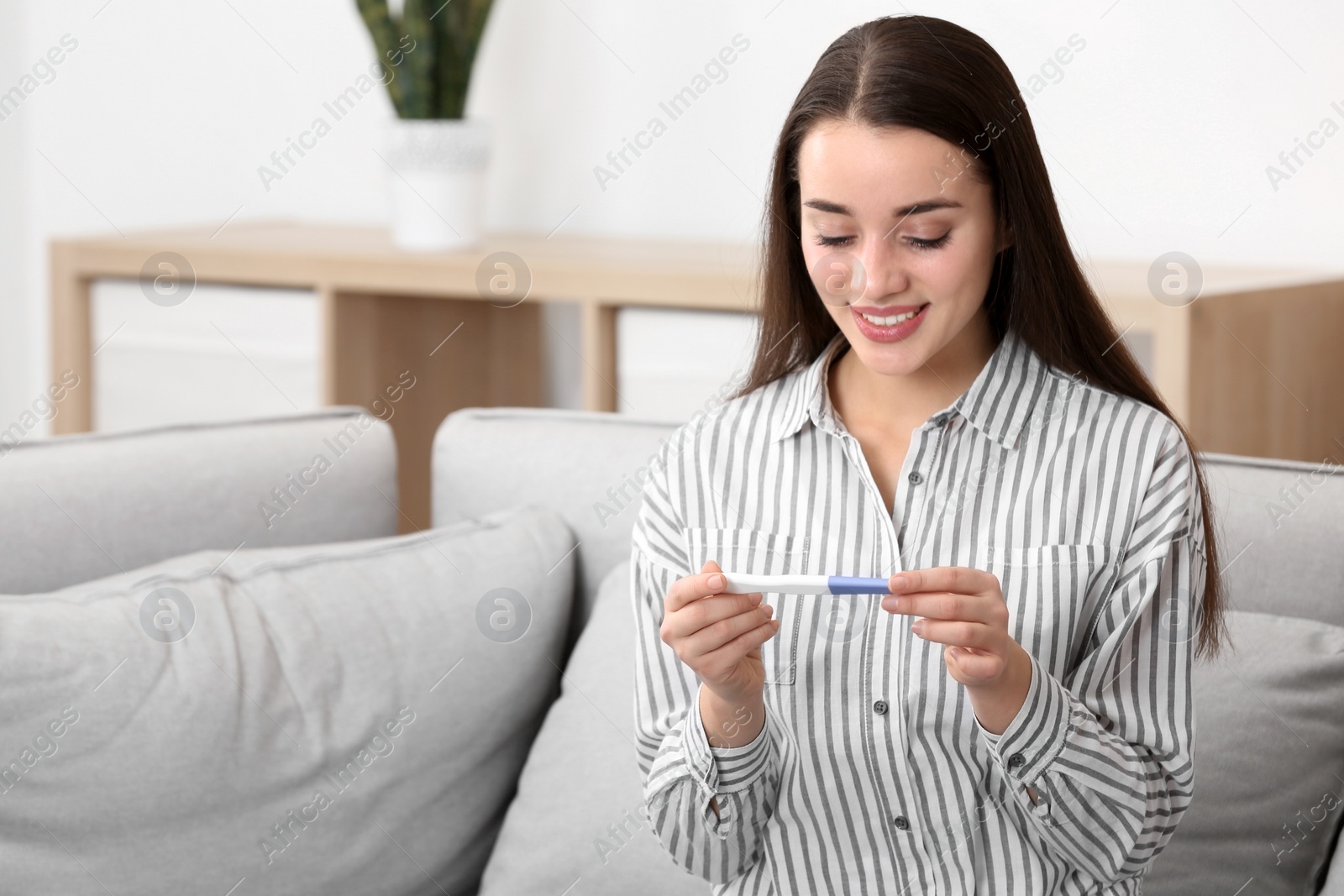 Photo of Young woman with pregnancy test at home. Gynecology and childbirth