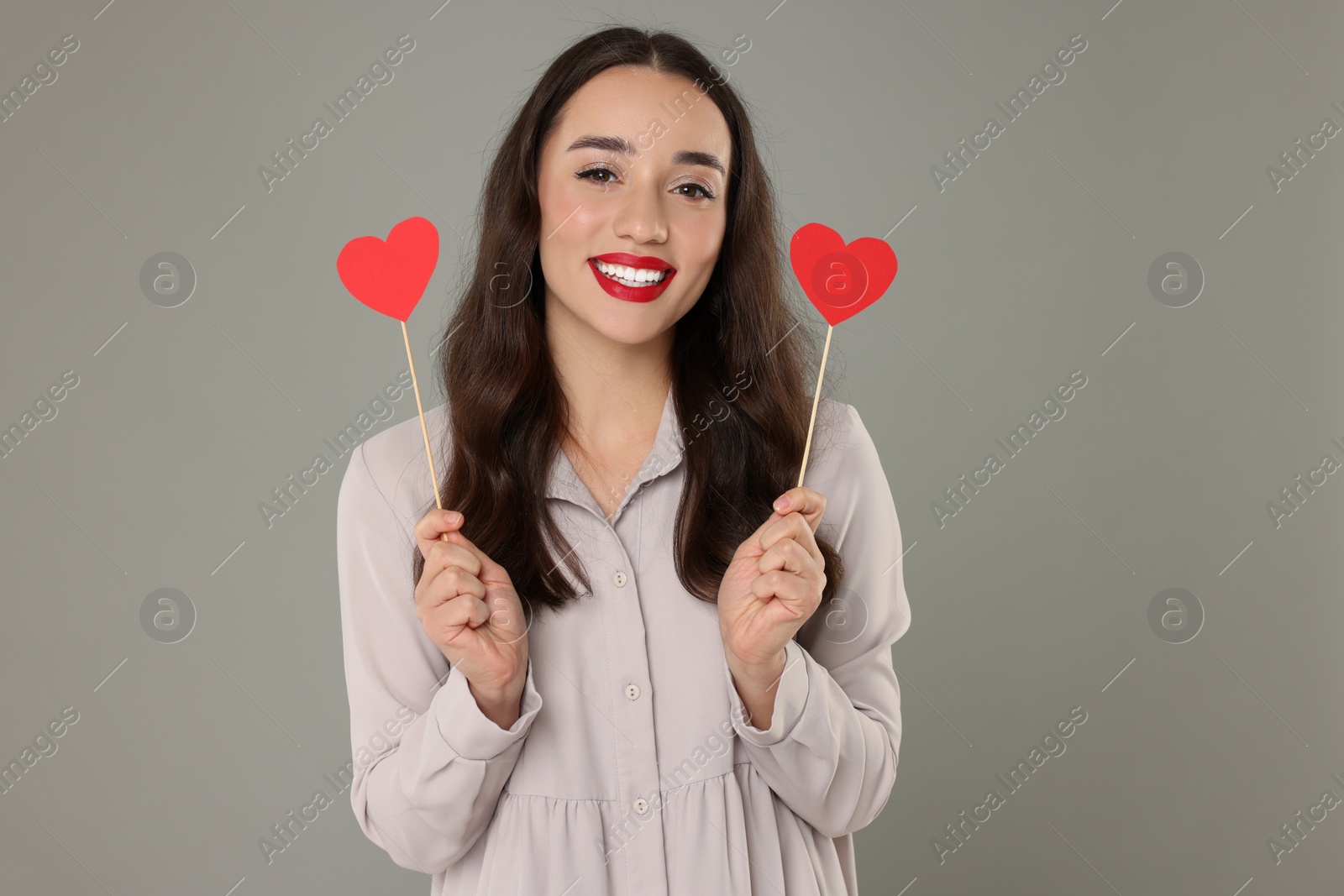 Photo of Beautiful young woman with paper hearts on grey background