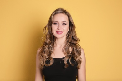 Photo of Portrait of young woman with long beautiful hair on color background