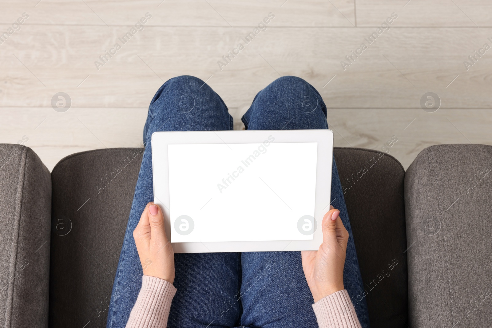 Photo of Woman working with tablet in armchair, top view