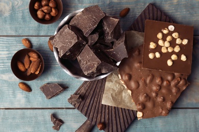 Different delicious chocolate on wooden table, top view