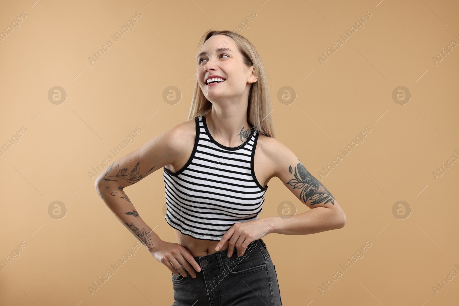 Photo of Portrait of beautiful tattooed woman on beige background