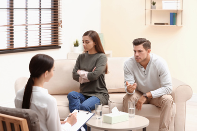 Photo of Professional psychologist working with couple in office