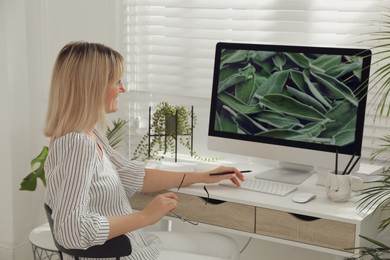 Woman working on computer at table in room. Interior design