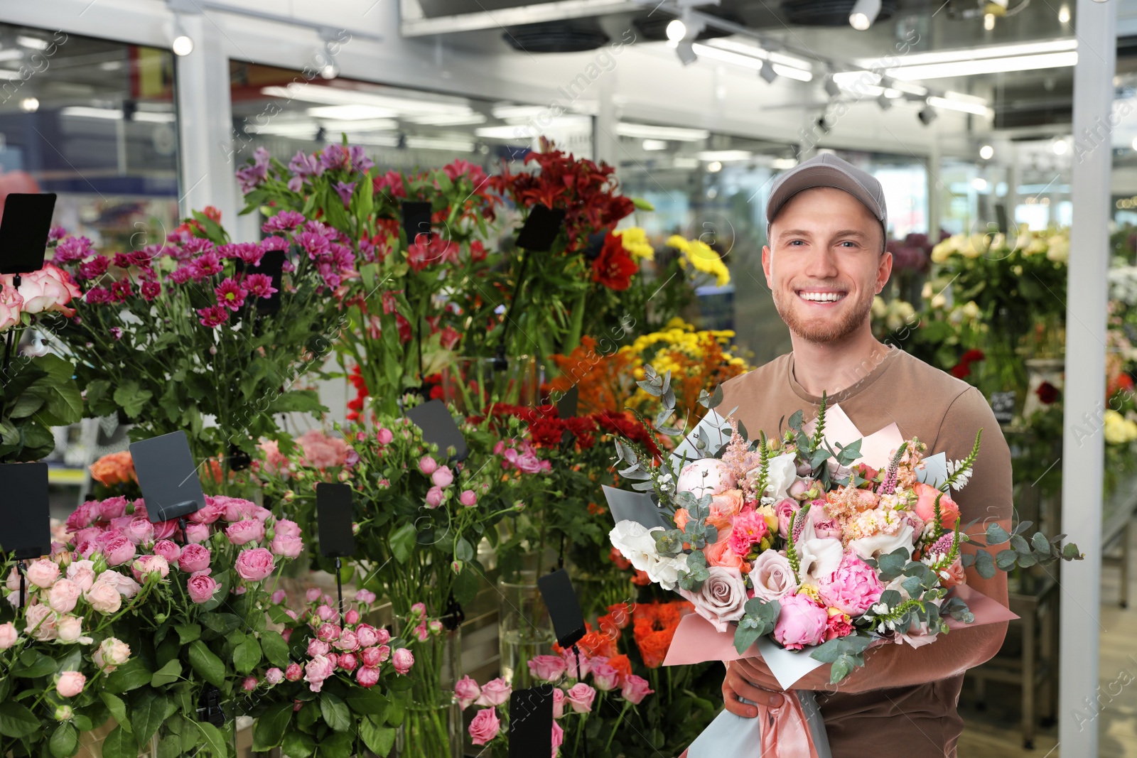 Image of Delivery man with beautiful bouquet in flower shop