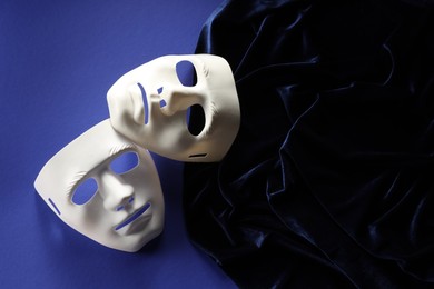 Theater arts. White masks and fabric on blue background, top view