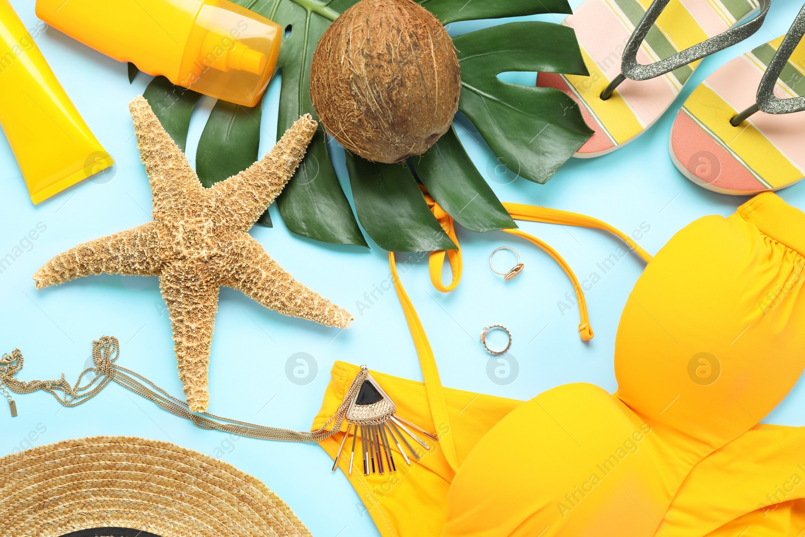 Photo of Flat lay composition with beach accessories on light blue background