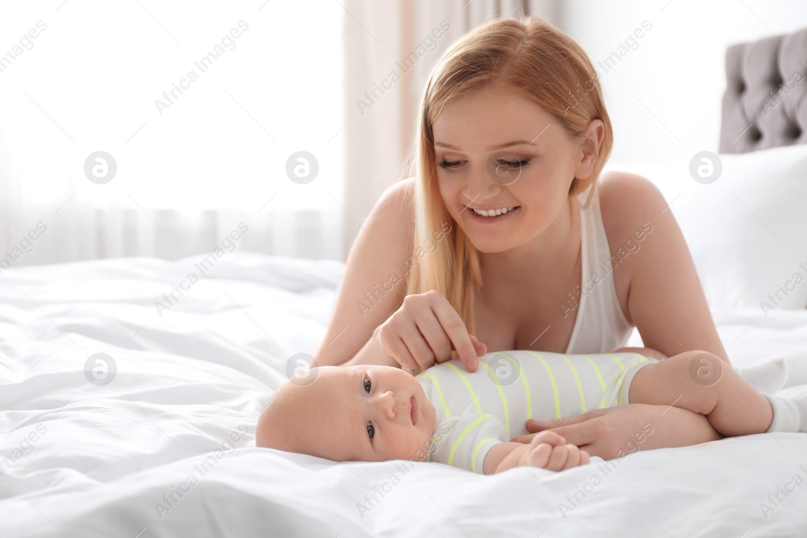 Photo of Mother with her little baby on bed at home