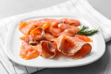 Photo of Plate with fresh sliced salmon fillet and rosemary on table