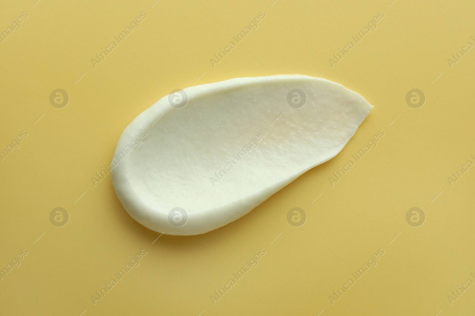 Photo of Sample of face scrub on yellow background, top view