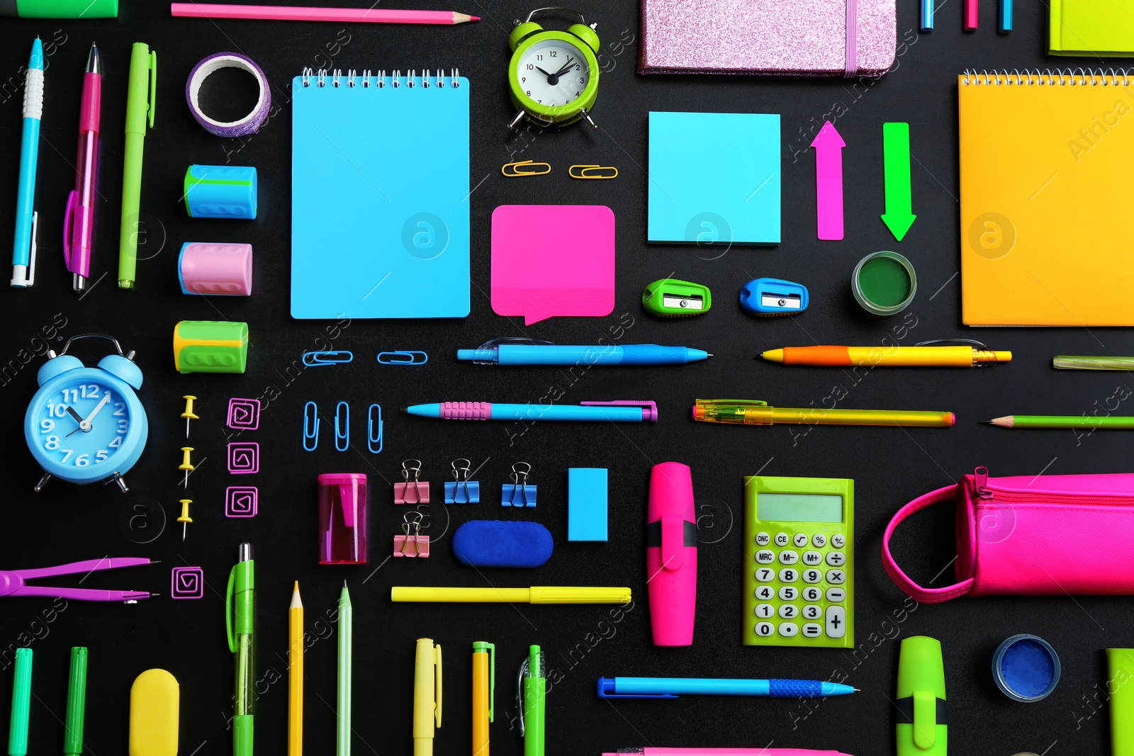 Photo of Different bright school stationery on black background, flat lay