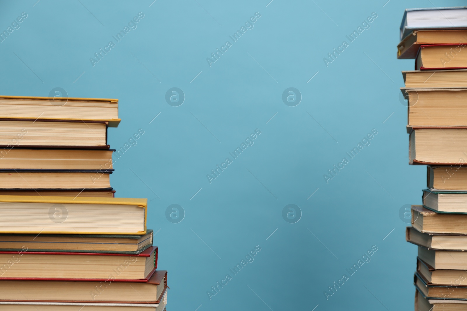 Photo of Many hardcover books on turquoise background, space for text. Library material