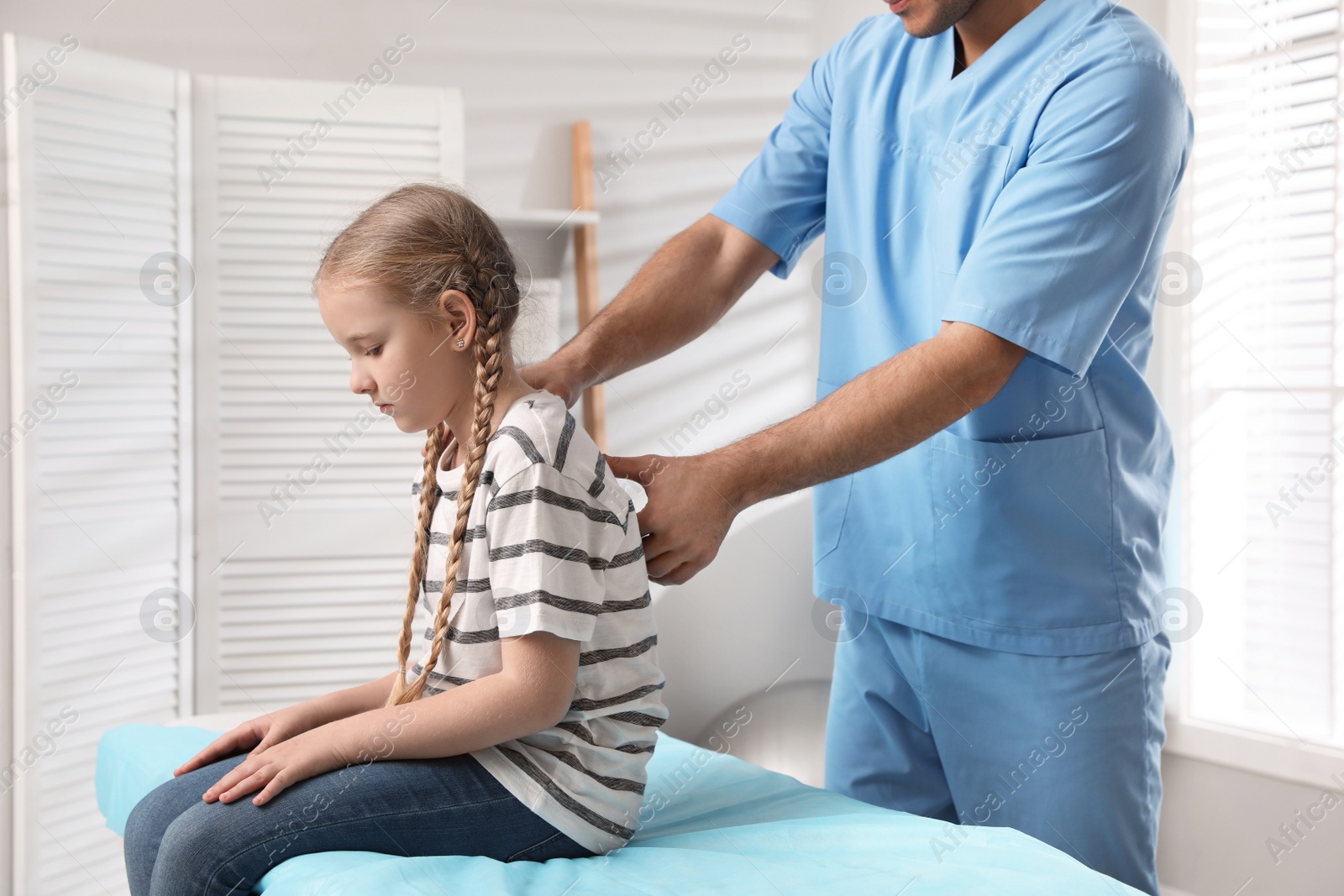 Photo of Orthopedist examining child's back in clinic, closeup. Scoliosis treatment