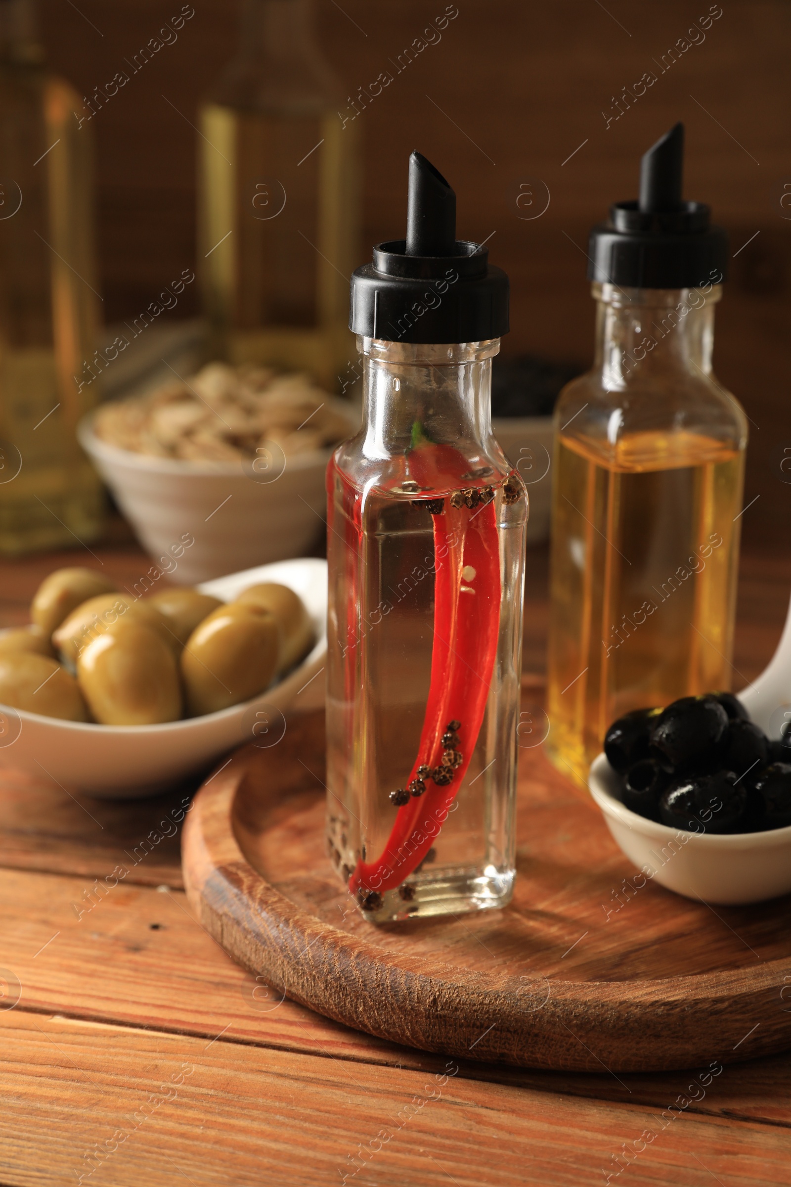 Photo of Different cooking oils and ingredients on wooden table