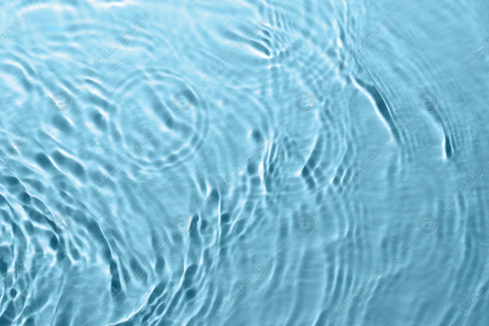 Image of Rippled surface of clear water on light blue background, top view