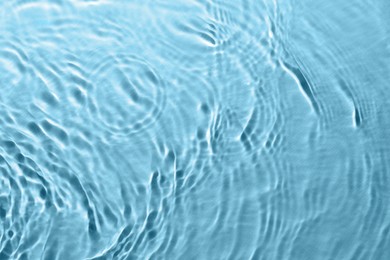 Rippled surface of clear water on light blue background, top view