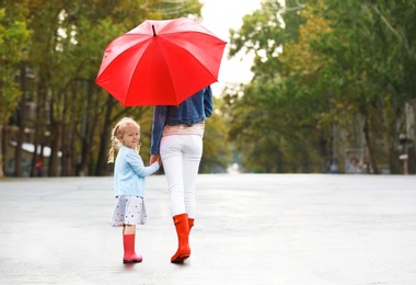 Photo of Mother and daughter with red umbrella on street