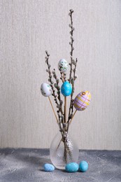 Beautiful willow branches with painted eggs on light grey table. Easter decor