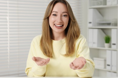 Young woman waving hello during video chat at home, view from webcam