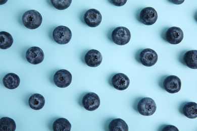 Photo of Fresh ripe blueberries on light blue background, flat lay