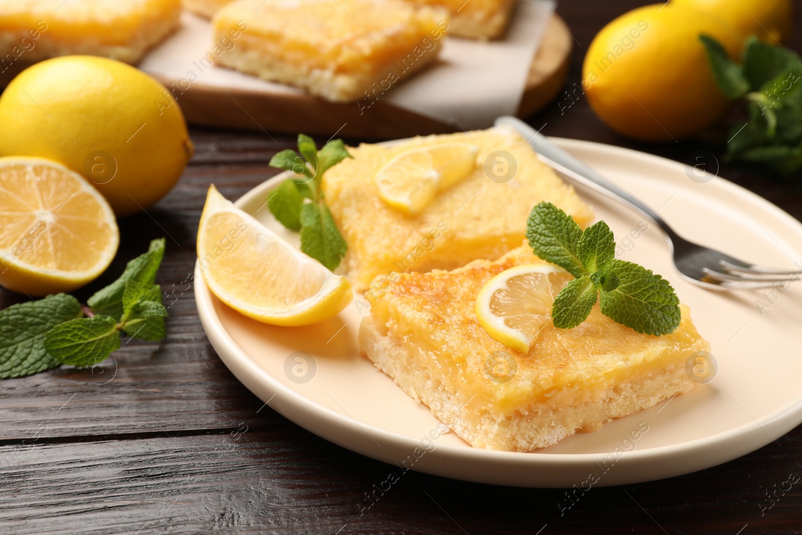 Photo of Tasty lemon bars served on wooden table, closeup