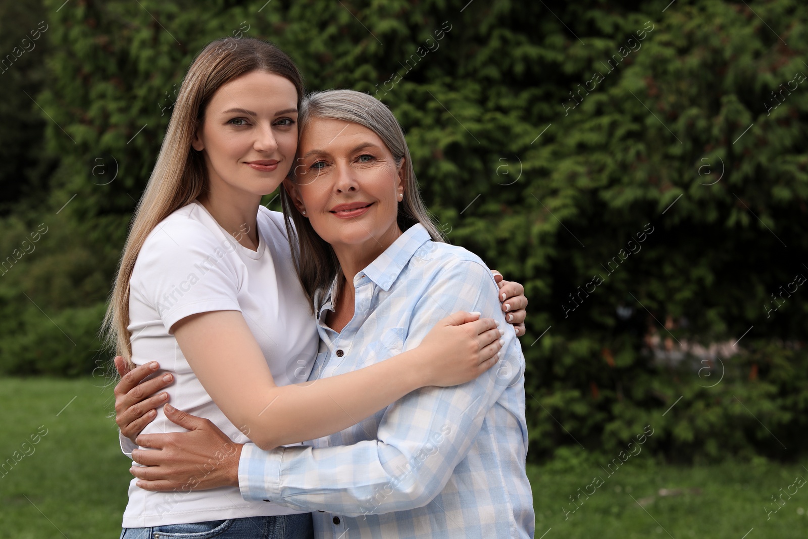 Photo of Happy mature mother and her daughter hugging in park