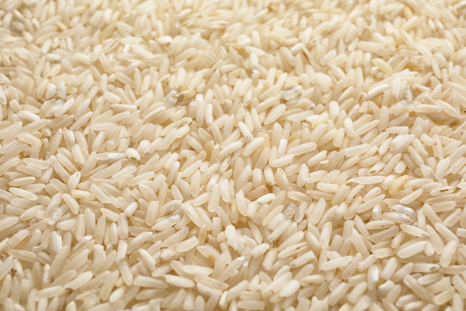 Photo of Pile of uncooked rice as background, closeup