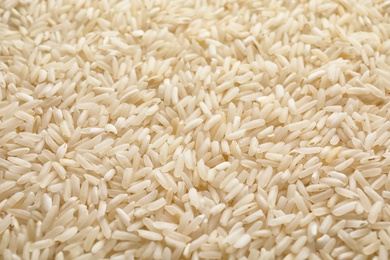 Pile of uncooked rice as background, closeup