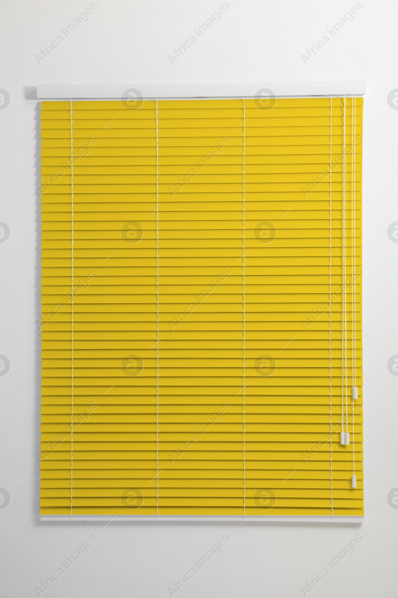 Image of Window with closed yellow blinds in room