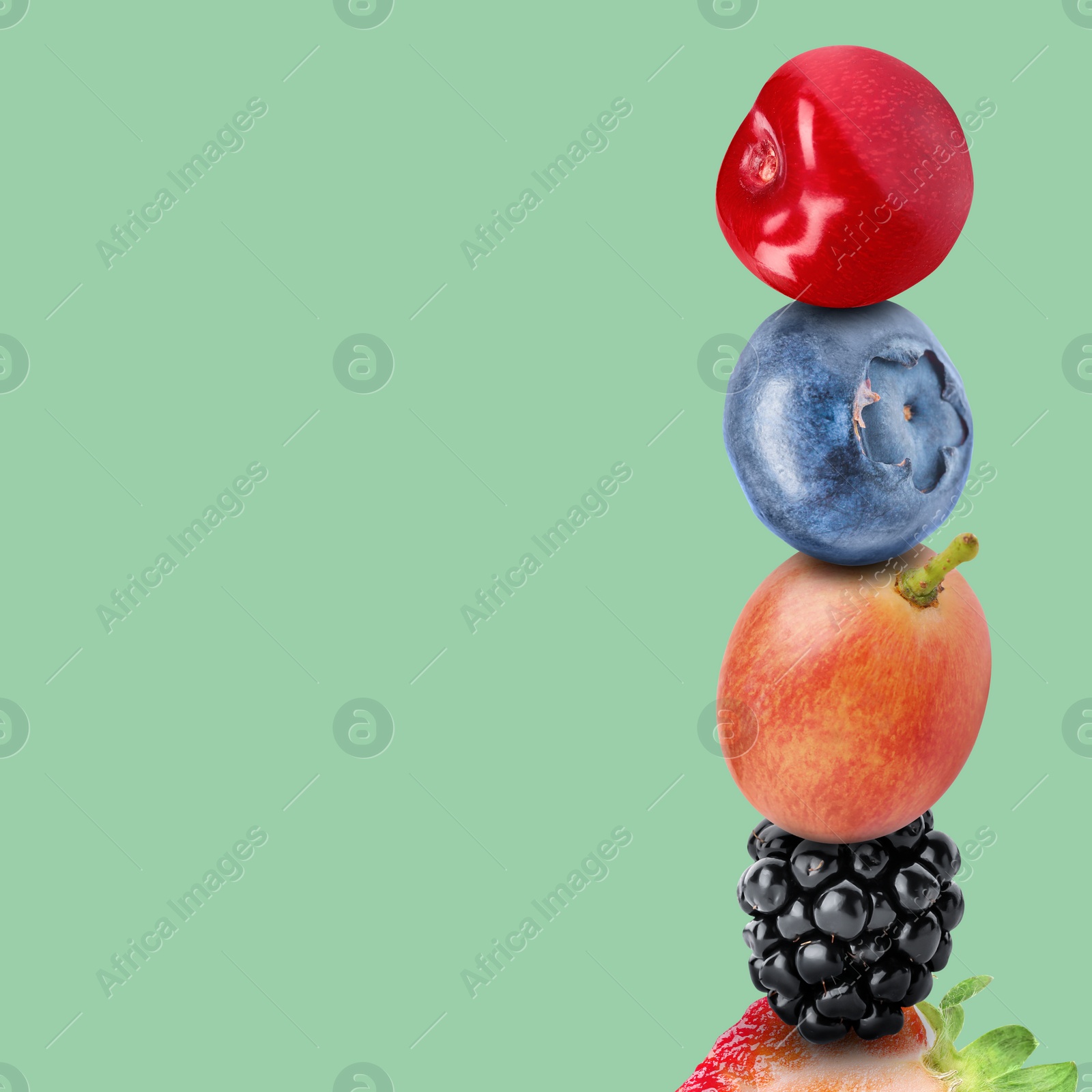 Image of Stack of different fresh tasty berries and cherry on pale aquamarine background, space for text