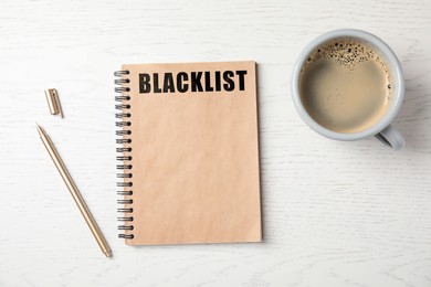 Image of Word Blacklist written in notepad, pen and coffee on white wooden table, flat lay
