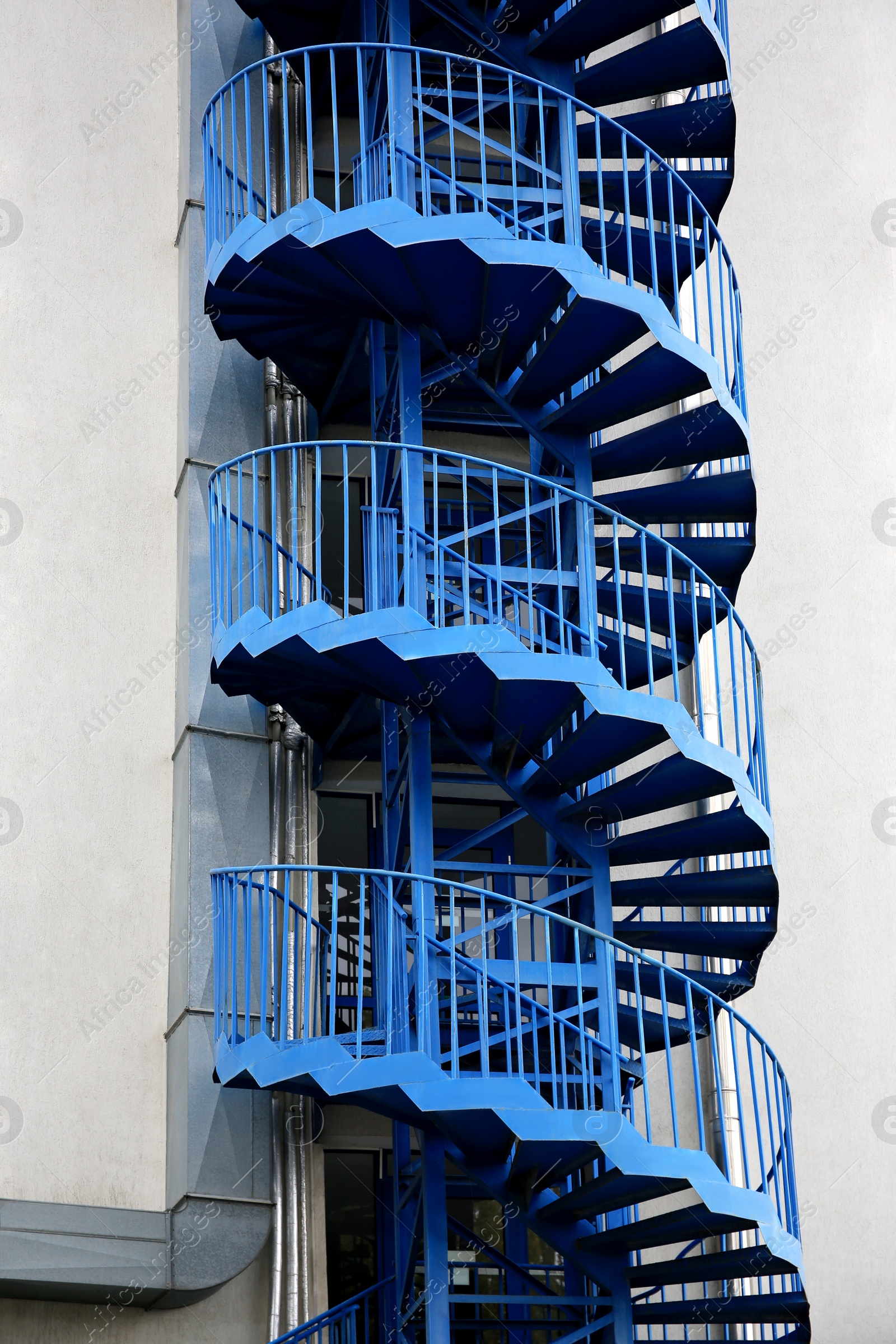 Photo of View of modern metal empty fire escape ladder near building outdoors