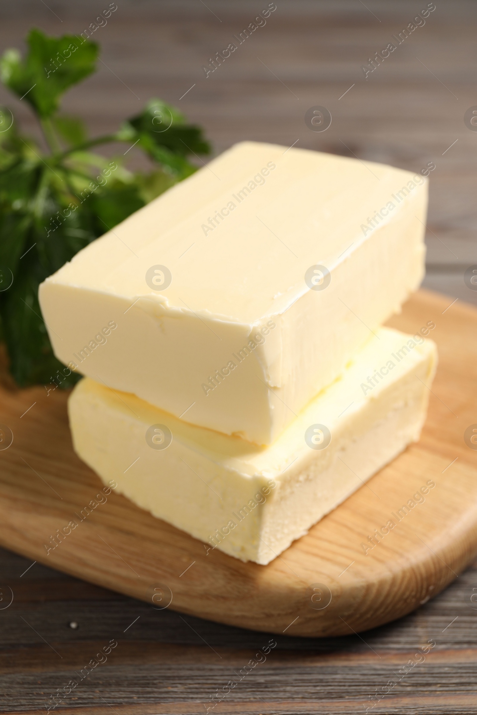 Photo of Tasty butter and parsley on wooden table, closeup