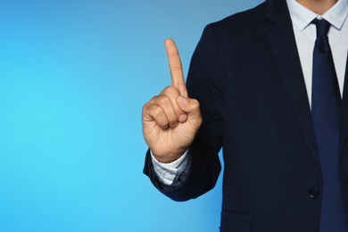 Photo of Businessman pointing on color background, closeup view of hand with space for text