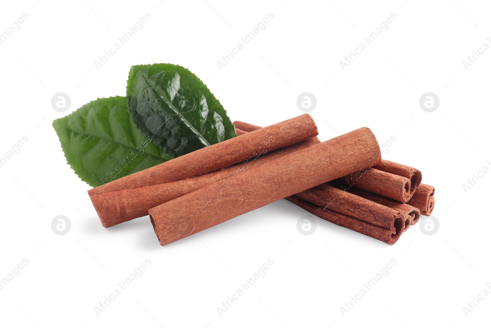 Photo of Aromatic cinnamon sticks and green leaves isolated on white