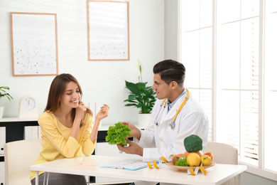 Nutritionist consulting patient at table in clinic