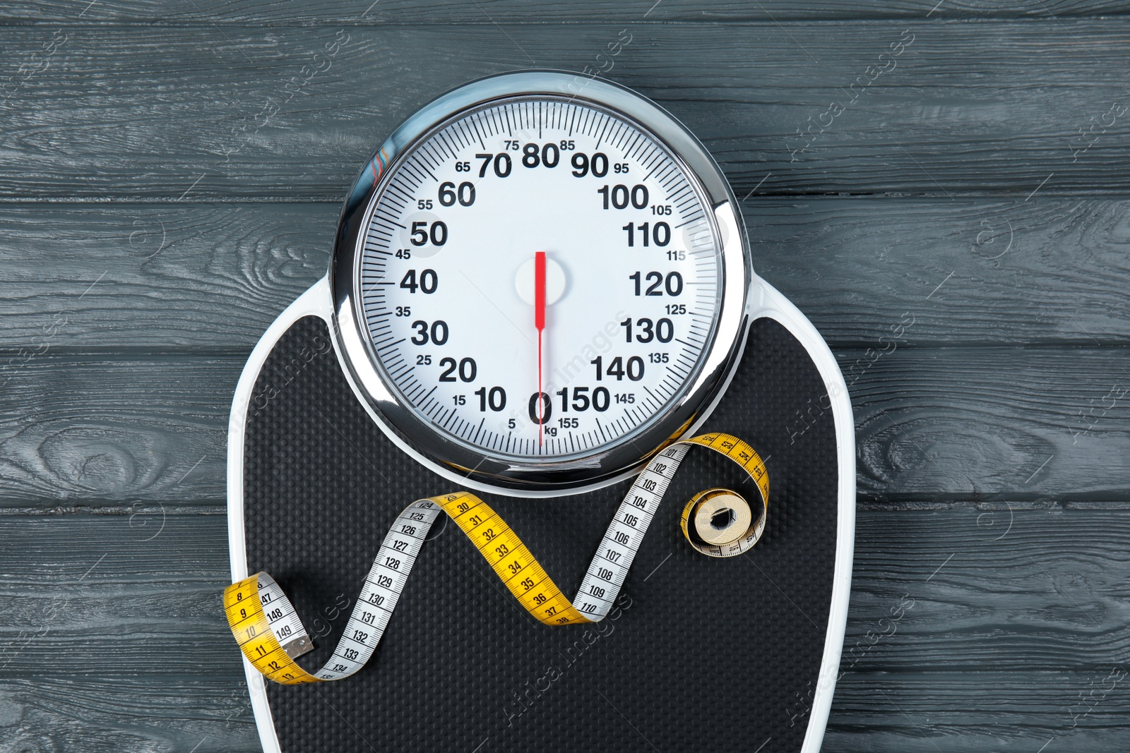 Photo of Scales and measuring tape on wooden background, top view. Weight loss